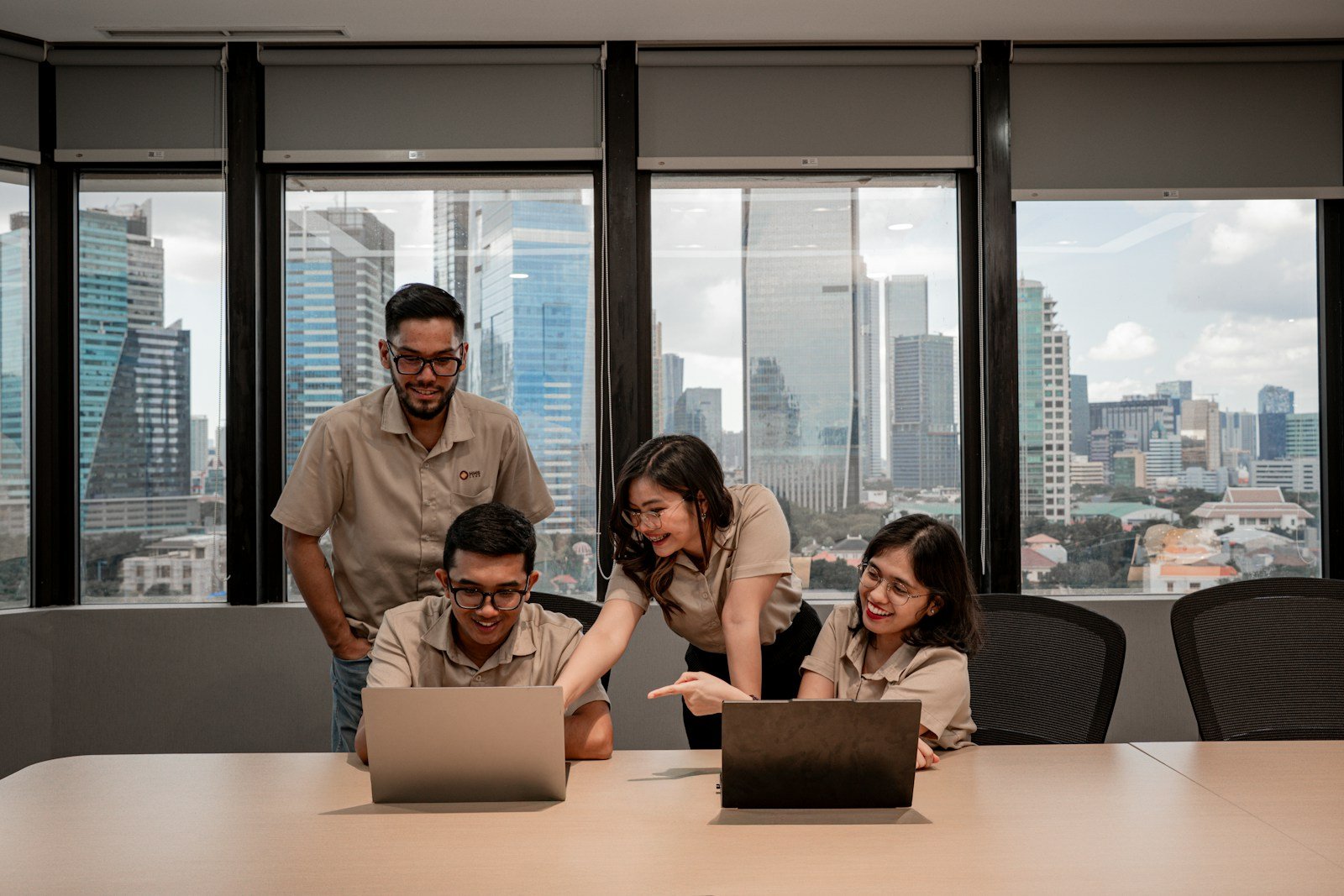 Equipo de profesionales colaborando con computadores en un espacio de trabajo